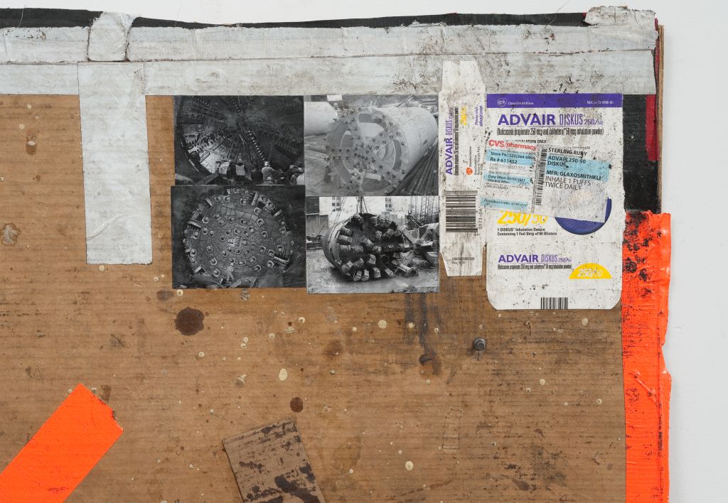 A detail of the image shows a piece of cardboard. The surface of the cardboard, which is partially traversed by coloured stripes, is covered with small black-and-white photographs. These depict industrial machinery. Next to them, packaging from American medications has been affixed.