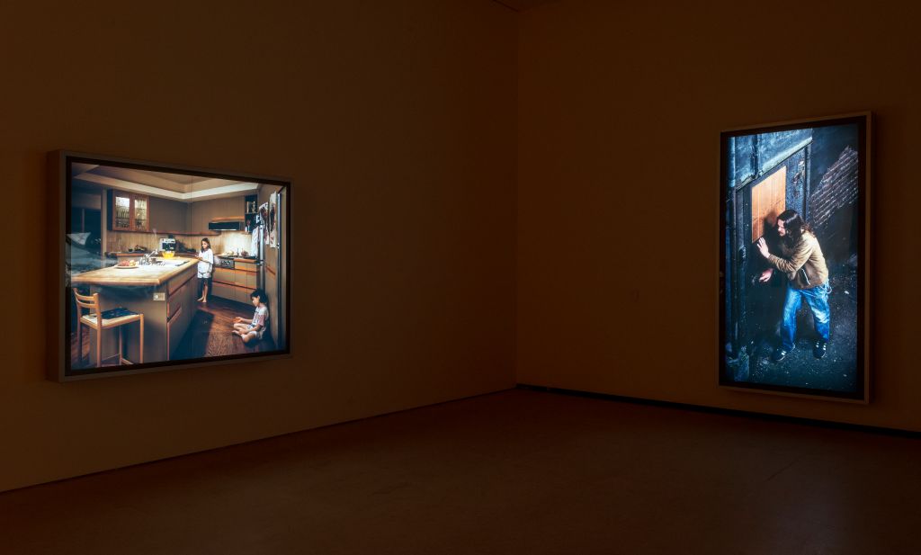 Two pictures can be seen hanging on the wall in a museum. The one on the right depicts 'Doorpusher' which is the focus here.