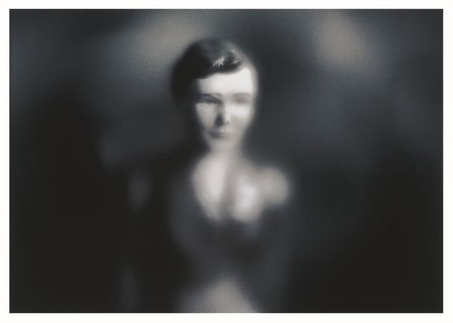 Der Kopf einer Puppe erscheint durch eine unscharfe Vignette. Die Fotografie ist in Schwarz-Weiß gehalten. 