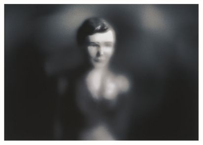 Der Kopf einer Puppe erscheint durch eine unscharfe Vignette. Die Fotografie ist in Schwarz-Weiß gehalten. 