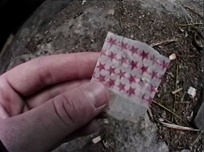 A hand holds a white paper package with red stars.