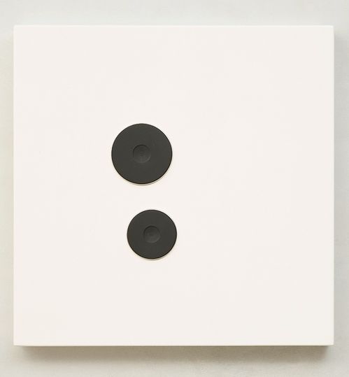 Zwei runde Herdplatten unterschiedlicher Größe auf einem stählernen, weißen, quadratischen Trägermaterial.