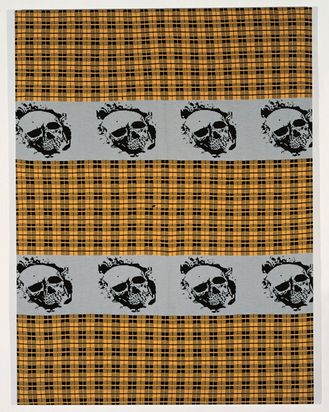 Ein quadratisches Strickstück mit schwarzem Karomuster auf ockerfarbenen Grund, zentral oben und unten zwei graufarbene Streifen mit einer sich wiederholenden schwarzfarbenen Totenkopfabbildung.