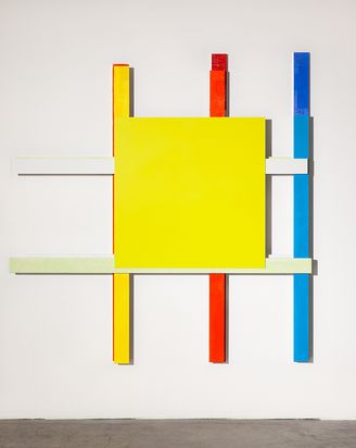 Wandobjekt aus zu einem Gitter geschichteten verschiedenfarbig bemalten Metallstäben. In der Mitte des Gitters ist eine quadratische gelbe Fläche angebracht.
