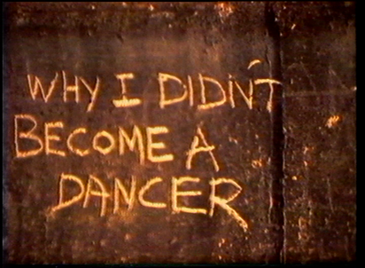 Light writing on dark wall "WHY I DIDN'T BECOME A DANCER".
