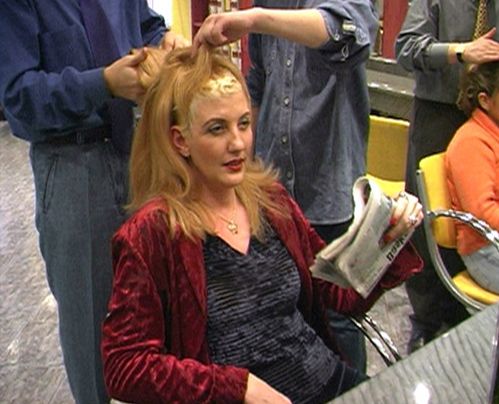 A woman has a wig put on in a hairdressing salon
