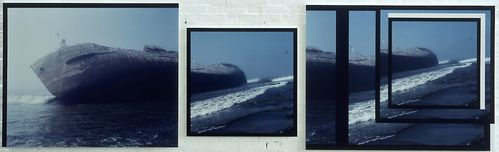 Three image elements depict a tanker stranded along a coastline and tilted to the left. The image of the tanker is divided across multiple sections, giving it a fragmented appearance. The overall colour tone is a cool blue.