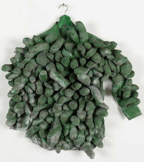 © YAYOI KUSAMA, photo: Thomas Dashuber A shirt on a clothes hanger is covered with filled fabric bags reminiscent of phailli and painted with green spray paint.