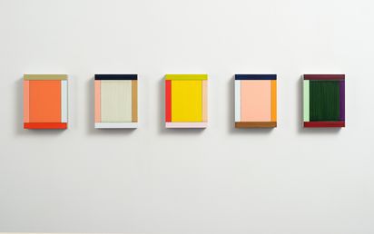 5 minimalistisch-abstrakte Wandobjekte hängen nebeneinander. Variationen eines monochromen Rechteckes, flankiert von einem Rand in einer weiteren Farbe auf jeder Seite.  