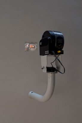 Beamer on unusual wall mount projects small image onto the wall.