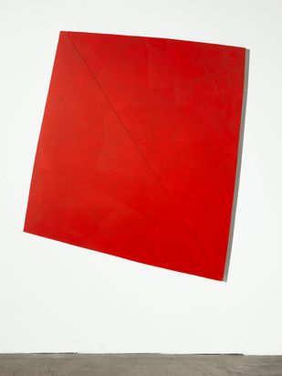 Zweiteiliges Wandobjekt. Zwei rote Dreiecke sind zu einem verzogenen Rechteck oder zu einer Raute zusammengefügt.