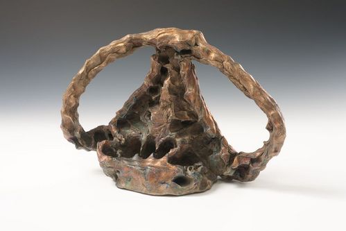 Eine Bronzeskulptur mit handgeformter Basis und einem sie überspannenden, bogenförmigen Element.